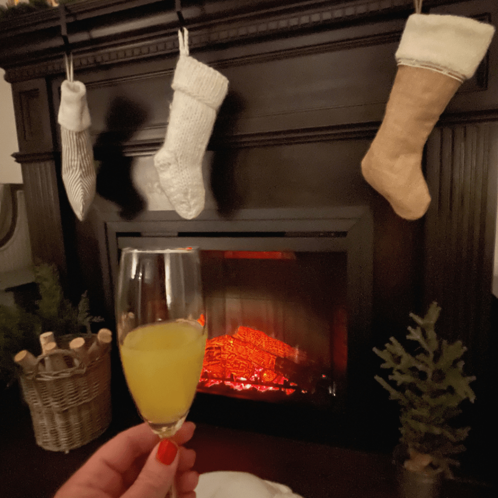 cozy fireplace at the holidays enjoying a mimosa 